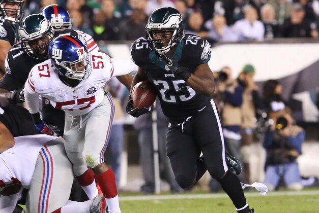 Oct 12, 2014; Philadelphia, PA, USA; Philadelphia Eagles running back LeSean McCoy (25) runs past New York Giants linebacker Jacquian Williams (57) during the first quarter at Lincoln Financial Field. Mandatory Credit: Bill Streicher-USA TODAY Sports