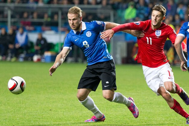 Estonia's Henri Anier, left, fights for the ball with England's Adam Lallana during the Euro 2016 qualifying soccer match between Estonia and England in Tallinn, Estonia, Sunday, Oct. 12, 2014. (AP Photo/Liis Treimann)