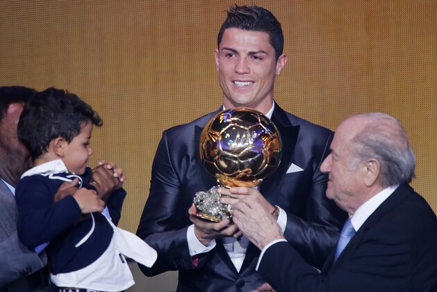 Real Madrid's world player Christiano Ronaldo of Portugal, center, FIFA President Joseph Blatter and Ronaldo's son Ronaldo Junior stand together at the FIFA Ballon d'Or 2013 Gala in Zurich, Switzerland, Monday, Jan. 13, 2014. (AP Photo/Michael Probst)