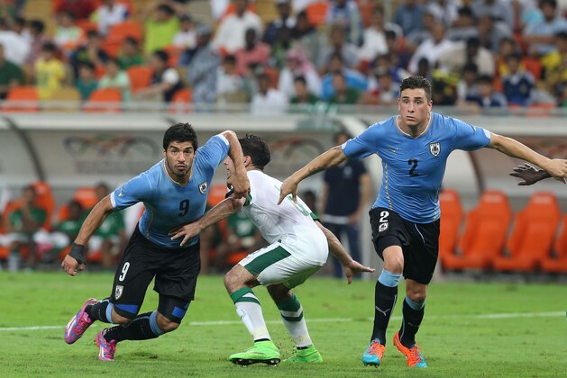 Uruguay's Luis Suarez, left, and Jose Gimenez, right, go for the ball during the international friendly soccer match between Saudi Arabia and Uruguay at King Abdullah stadium in Jeddah, Saudi Arabia, Friday, Oct. 10, 2014. (AP Photo)