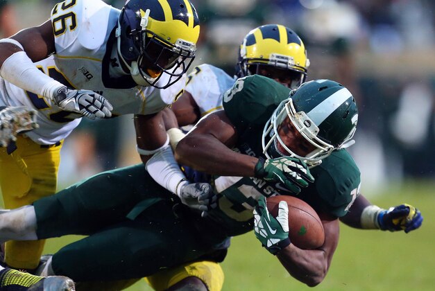 Nov 2, 2013; East Lansing, MI, USA; Michigan State Spartans wide receiver Bennie Fowler (13) is tackled by Michigan Wolverines defensive back Jourdan Lewis (26) during the 2nd half of a game at Spartan Stadium. MSU won 29-6. Mandatory Credit: Mike Carter-USA TODAY Sports
