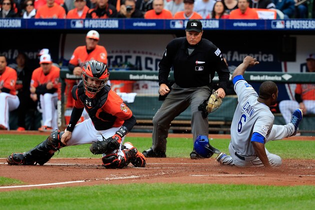 BALTIMORE, MD - OCTOBER 11:  Lorenzo Cain #6 of the Kansas City Royals slides save to home plate on Eric Hosmer #35 of the Kansas City Royals single to left field also scoring Norichika Aoki #23 in the first inning against Bud Norris #25 of the Baltimore Orioles during Game Two of the American League Championship Series at Oriole Park at Camden Yards on October 11, 2014 in Baltimore, Maryland.  (Photo by Rob Carr/Getty Images)