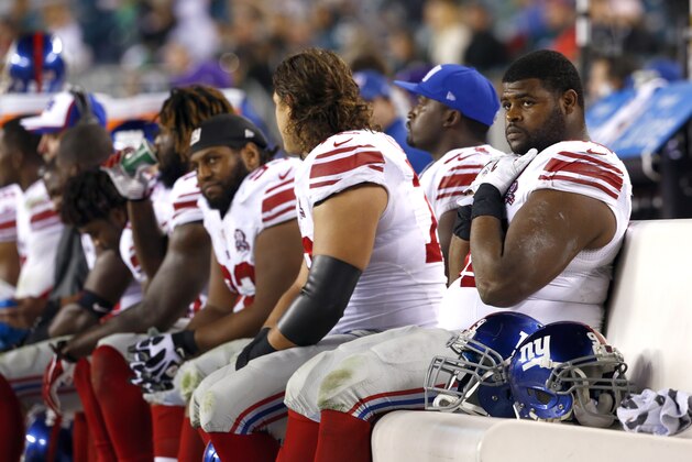 New York Giants defensive tackle Johnathan Hankins, right, sits on the bench with teammates during the second half of an NFL football game against the Philadelphia Eagles, Sunday, Oct. 12, 2014, in Philadelphia. (AP Photo/Matt Rourke)