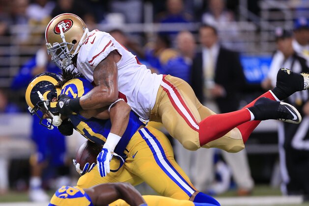 San Francisco 49ers outside linebacker Ahmad Brooks, top, brings down St. Louis Rams running back Tre Mason (27) in the first quarter of an NFL football game Monday, Oct. 13, 2014, in St Louis. (AP Photo/Billy Hurst)