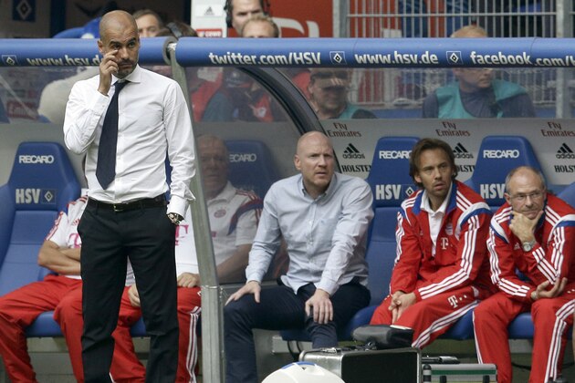 Bayern head coach Pep Guardiola of Spain, left, attends the German Bundesliga soccer match between Hamburger SV and FC Bayern Munich in Hamburg, Germany, Saturday, Sept. 20, 2014. The match ended in a 0-0 draw. (AP Photo/Michael Sohn)