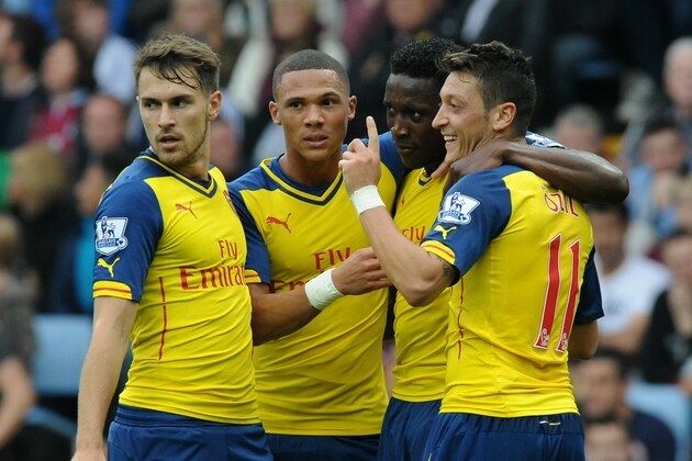 Arsenal's Mesut Ozil, right, celebrates with Aaron Ramsey, left, Alex Oxlade-Chamberlain, second left, and Danny Welbeck after scoring against Villa during the English Premier League soccer match between Aston Villa and Arsenal at Villa Park, Birmingham, England, Saturday, Sept. 20, 2014. (AP Photo/Rui Vieira)