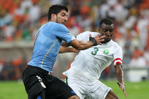 Uruguay's Luis Suarez, left, fights for the ball against Saudi Arabia's Osama Hawsawi during the international friendly soccer match between Saudi Arabia and Uruguay at King Abdullah stadium in Jeddah, Saudi Arabia, Friday, Oct. 10, 2014. (AP Photo)