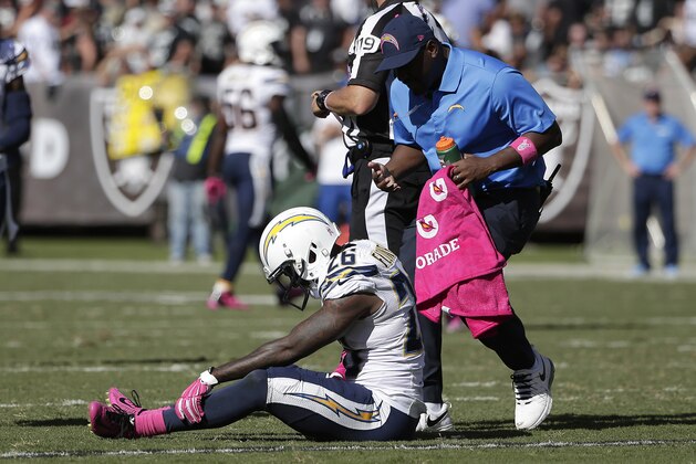 San Diego Chargers defensive back Brandon Flowers (26) sits on the ground as a trainer tends to him during the third quarter of an NFL football game against the Oakland Raiders in Oakland, Calif., Sunday, Oct. 12, 2014. (AP Photo/Marcio Jose Sanchez)