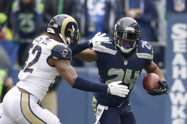 Seattle Seahawks running back Marshawn Lynch (24) rushes against St. Louis Rams outside linebacker Alec Ogletree (52) in the first half of an NFL football game, Sunday, Dec. 29, 2013, in Seattle. (AP Photo/Elaine Thompson)
