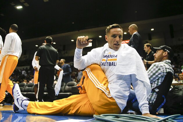 Los Angeles Lakers guard Steve Nash sits on the end of the court while doing stretching exercises to relieve his back during the first half of a NBA preseason basketball game  Monday, Oct. 6, 2014, in San Diego. (AP Photo/Lenny Ignelzi