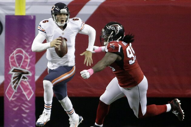 Chicago Bears quarterback Jay Cutler (6) runs from Atlanta Falcons defensive end Jonathan Babineaux (95) during the second half of an NFL football game, Sunday, Oct. 12, 2014, in Atlanta. (AP Photo/David Goldman)