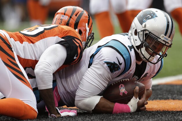 Carolina Panthers quarterback Cam Newton, right, lays in the end zone after scoring against Cincinnati Bengals cornerback Terence Newman on a 12-yard run in the second second half of an NFL football game, Sunday, Oct. 12, 2014, in Cincinnati. (AP Photo/AJ Mast)