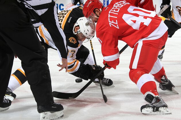 DETROIT, MI - OCTOBER 9:  Patrice Bergeron #37 of the Boston Bruins and Henrik Zetterberg #40 of the Detroit Red Wings face-off during the NHL season opener on October 9, 2014 at Joe Louis Arena in Detroit, Michigan. Detroit defeated Boston 2-1(Dave Reginek/NHLI via Getty Images)