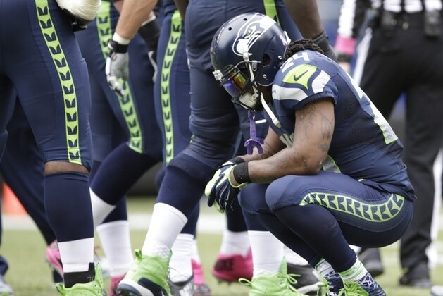 Seattle Seahawks' Marshawn Lynch crouches down during a timeout in the second half of an NFL football game against the Dallas Cowboys, Sunday, Oct. 12, 2014, in Seattle. (AP Photo/Scott Eklund)