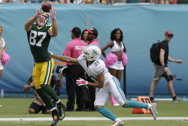 Green Bay Packers wide receiver Jordy Nelson (87) stretches to catch a pass as Miami Dolphins cornerback Brent Grimes (21) attempts to tackle during the first half of an NFL football game, Sunday, Oct. 12, 2014, in Miami Gardens, Fla. (AP Photo/Wilfredo Lee)
