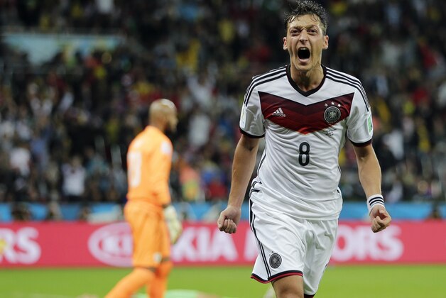 Germany's Mesut Ozil celebrates after scoring his side's second goal in extra time during the World Cup round of 16 soccer match between Germany and Algeria at the Estadio Beira-Rio in Porto Alegre, Brazil, Monday, June 30, 2014. Germany defeated Algeria 2-1 to advance to the quarterfinals.  (AP Photo/Matthias Schrader)
