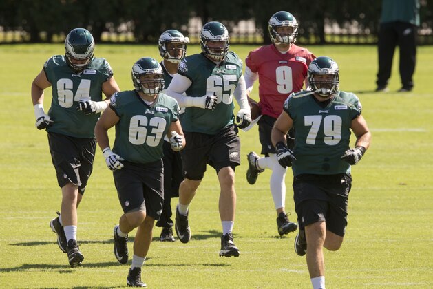 Philadelphia Eagles offensive tackle Lane Johnson (65) along with tackle Matt Tobin (64), center David Molk (63) wide receiver Jordan Matthews, center back, quarterback Nick Foles (9), and guard Todd Herremans (79) run to their next drill during NFL football practice at the team's training facility, Tuesday, Sept. 30, 2014, in Philadelphia. (AP Photo/Matt Rourke)