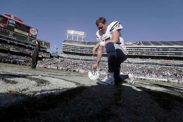 San Diego Chargers quarterback Philip Rivers (17) kneels on the field after the Chargers defeated the Oakland Raiders 31-28 in an NFL football game in Oakland, Calif., Sunday, Oct. 12, 2014. (AP Photo/Marcio Jose Sanchez)