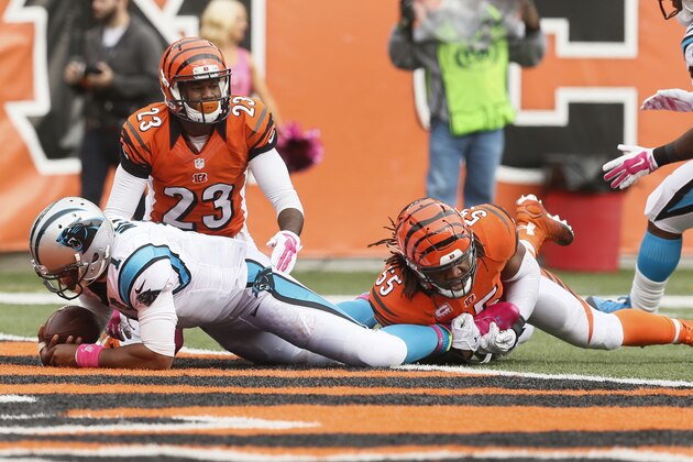 Carolina Panthers quarterback Cam Newton (1) runs through Cincinnati Bengals cornerback Terence Newman (23) and outside linebacker Vontaze Burfict (55) for a 12-yard touchdown in the second half of an NFL football game, Sunday, Oct. 12, 2014, in Cincinnati. (AP Photo/Paul Sancya)