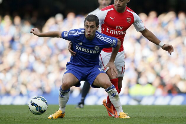 Chelsea's Eden Hazard, left, holds off the challenge of Arsenal's Alex Oxlade-Chamberlain during their English Premier League soccer match between Chelsea and Arsenal at Stamford Bridge stadium in London Sunday, Oct. 5, 2014. (AP Photo/Alastair Grant)