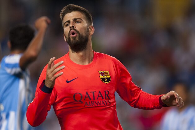 FC Barcelona's Gerard Pique, gestures during a Spanish La Liga soccer match between Malaga and Barcelona at La Rosaleda stadium in Malaga, Spain, Wednesday, Sept. 24, 2014. (AP Photo/Daniel Tejedor)