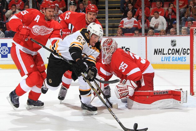 DETROIT, MI - OCTOBER 15:  Brad Marchand #63 of the Boston Bruins reaches for the puck as Niklas Kronwall #55, Jonathan Ericsson #52 and Jimmy Howard #35 of the Detroit Red Wings all close in during a NHL game on October 15, 2014 at Joe Louis Arena in Detroit, Michigan. (Dave Reginek/NHLI via Getty Images)