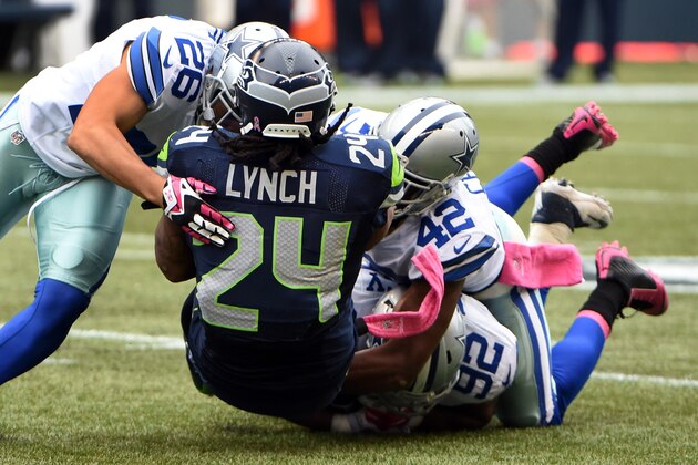 SEATTLE, WA - OCTBER 12: Running back Marshawn Lynch #24 of the Seattle Seahawks is tackled by defensive back Sterling Moore #26, free safety Barry Church #42 and defensive end Jeremy Mincey #92 of the Dallas Cowboys during the fourth quarter of the game at CenturyLink Field on October 12, 2014 in Seattle,Washington. (Photo by Steve Dykes/Getty Images)