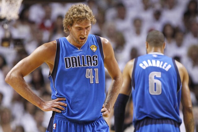 Dallas Mavericks' Dirk Nowitzki (41) takes a break as Tyson Chandler (6) is seen on right, during the first half of Game 1 of the NBA Finals basketball game  against the Miami Heat, Tuesday, May 31, 2011, in Miami. (AP Photo/Lynne Sladky)