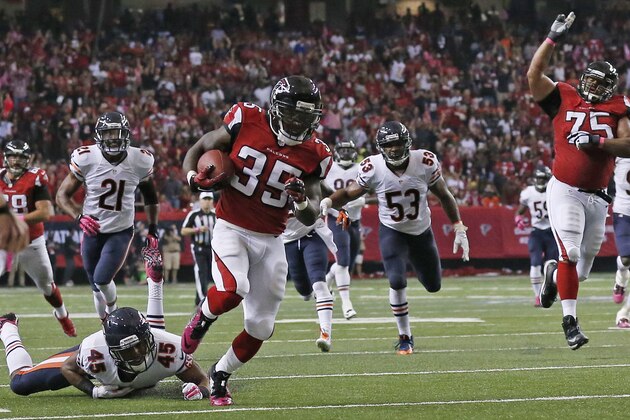 Atlanta Falcons running back Antone Smith (35) runs by Chicago Bears strong safety Brock Vereen (45) as Atlanta Falcons guard Jon Asamoah (75) reacts during the second half of an NFL football game, Sunday, Oct. 12, 2014, in Atlanta. Smith scored a touchdown on the play. (AP Photo/Brynn Anderson )