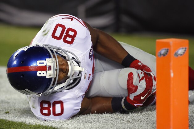 Víctor Cruz, receptor de los Giants de Nueva York, se sujeta la rodilla derecha tras lesionarse en el partido del domingo 12 de octubre de 2014, frente a los Eagles de Filadelfia (AP Foto/Matt Rourke)