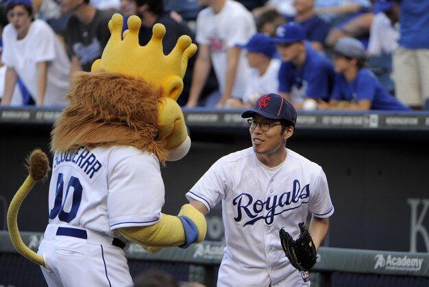 Aug 11, 2014; Kansas City, MO, USA; Kansas City Royals mascot Sluggerrr talks to SungWoo Lee, a Royals fan from South Korea, before the game against the Oakland Athletics at Kauffman Stadium. Kansas City won the game 3-2.  Mandatory Credit: John Rieger-USA TODAY Sports