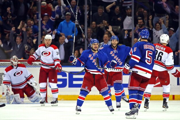 Oct 16, 2014; New York, NY, USA; New York Rangers center Derick Brassard (16) celebrates scoring a goal on Carolina Hurricanes goalie Anton Khudobin (31) with defenseman Dan Girardi (5) and right wing Mats Zuccarello (36) during the third period at Madison Square Garden. The Rangers defeated the Hurricanes 2-1. Mandatory Credit: Adam Hunger-USA TODAY Sports