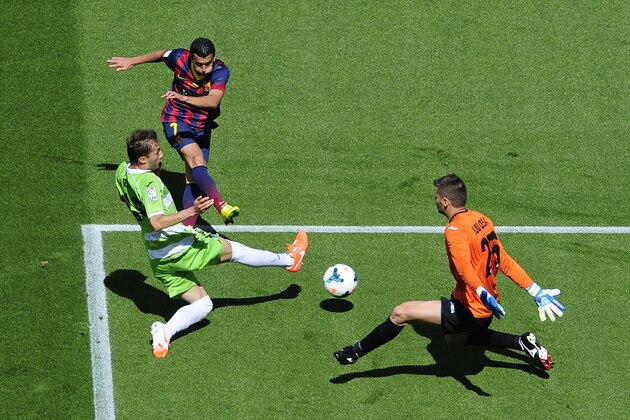 FC Barcelona's Pedro Rodriguez, second left, duels for the ball against Getafe's Rafa Lopez, left, and goalkeeper Julio Cesar, right, during a Spanish La Liga soccer match at the Camp Nou stadium in Barcelona, Spain, Saturday, May 3, 2014. (AP Photo/Manu Fernandez)