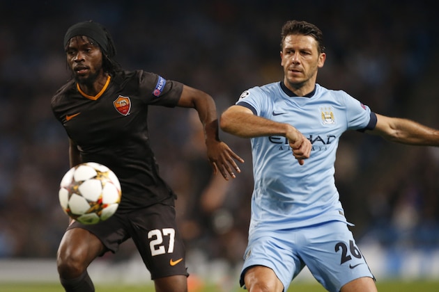 Manchester City's Martin Demichelis, right, and Roma's Gervinho goes for the ball during a Champions League group E soccer match between Manchester City and Roma at the Etihad Stadium, Manchester, England, Tuesday, Sept. 30, 2014. (AP Photo/Jon Super)