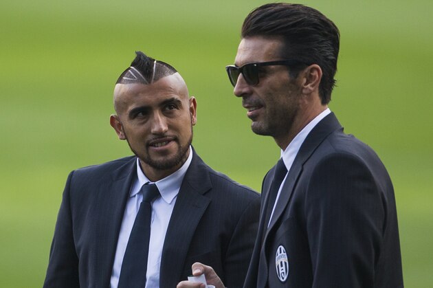 Juventus players Arturo Vidal, left, speaks to Gianluigi Buffon, right, as they visit the stadium ahead of Wednesday's Champions League soccer match between Atletico Madrid and Juventus, in Madrid, Spain, Tuesday, Sept. 30, 2014. (AP Photo/Andres Kudacki)