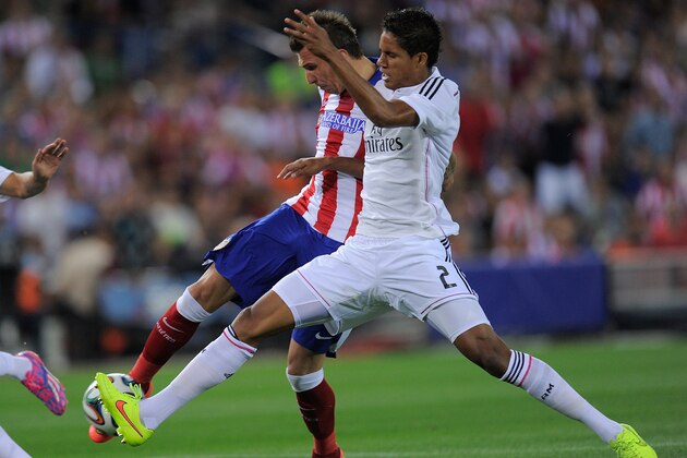 MADRID, SPAIN - AUGUST 22:  Mario Mandzukic of Club Atletico de Madrid beats Raphael Varane of Real Madrid to score his team's opening goal during the Supercopa, second leg match between Club Atletico de Madrid and Real Madrid at Vicente Caldron stadium on August 22, 2014 in Madrid, Spain.  (Photo by Denis Doyle/Getty Images)