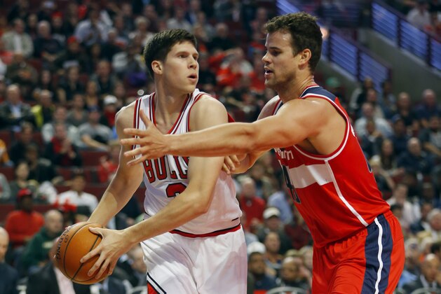 Chicago Bulls forward Doug McDermott, left, is guarded by Washington Wizards forward Kris Humphries, right, during the first half of a preseason NBA basketball game in Chicago, Monday Oct. 6, 2014. (AP Photo/Jeff Haynes)