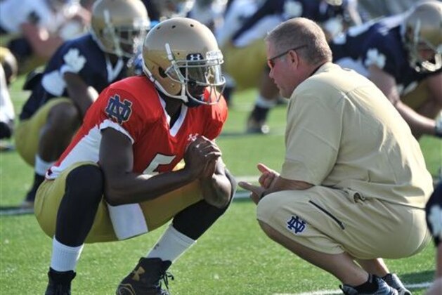 FILE - In this Aug. 9, 2014, file photo, Notre Dame coach Brian Kelly, right, talks with quarterback Everett Golson during practice in South Bend, Ind. Golson has reclaimed the job as Notre Dame's starting quarterback after being suspended last semester for academic impropriety. Coach Brian Kelly on Wednesday, Aug. 13, 2014, said Golson would start against Rice on Aug. 30 and said he hopes he will be the starter for the entire season.  (AP Photo/Joe Raymond, FILE)