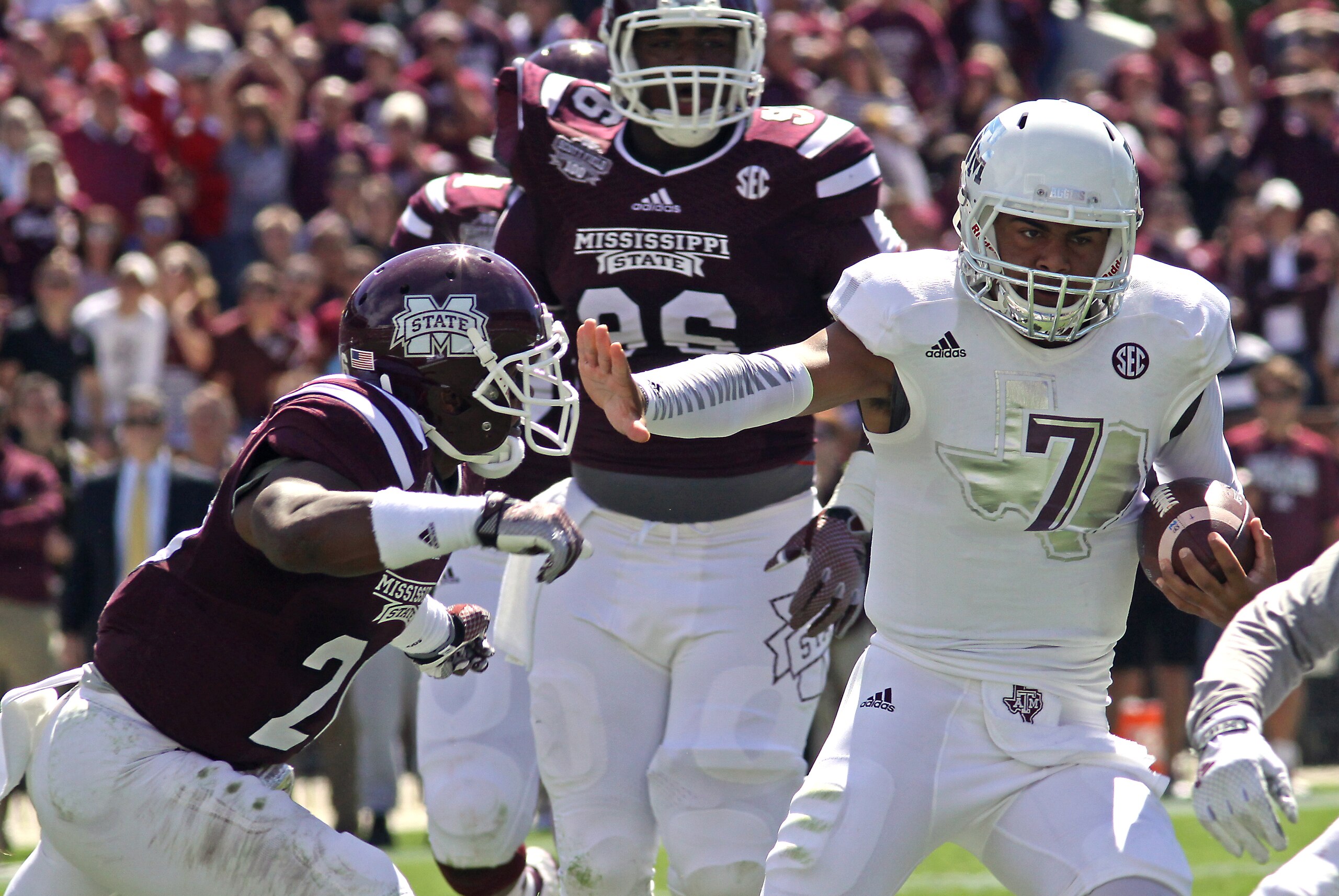 Texas A&M quarterback Kenny Hill (7) stiff arms Mississippi State defensive back Kendrick Market, left as Mississippi State defensive lineman Chris Jones (96) defends during the first half of an NCAA college football game in Starkville, Miss., Saturday, Oct. 4, 2014. (AP Photo/Jim Lytle)