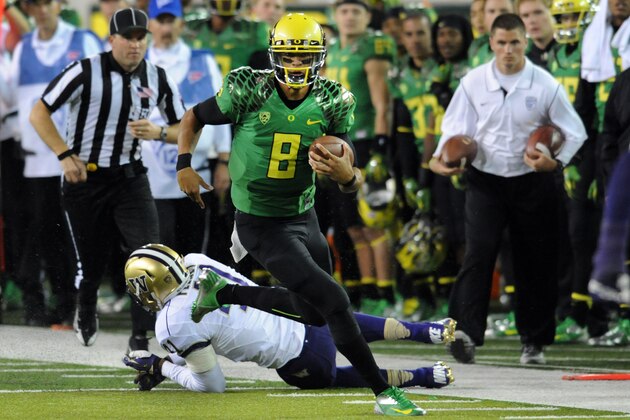 EUGENE, OR - OCTOBER 6: Quarterback Marcus Mariota #8 of the Oregon Ducks avoids the tackle of linebacker Travis Feeney #41 of the Washington Huskies closes in during the first quarter of the game on October 6, 2012 at Autzen Stadium in Eugene, Oregon. Oregon won the game 52-21. (Photo by Steve Dykes/Getty Images)