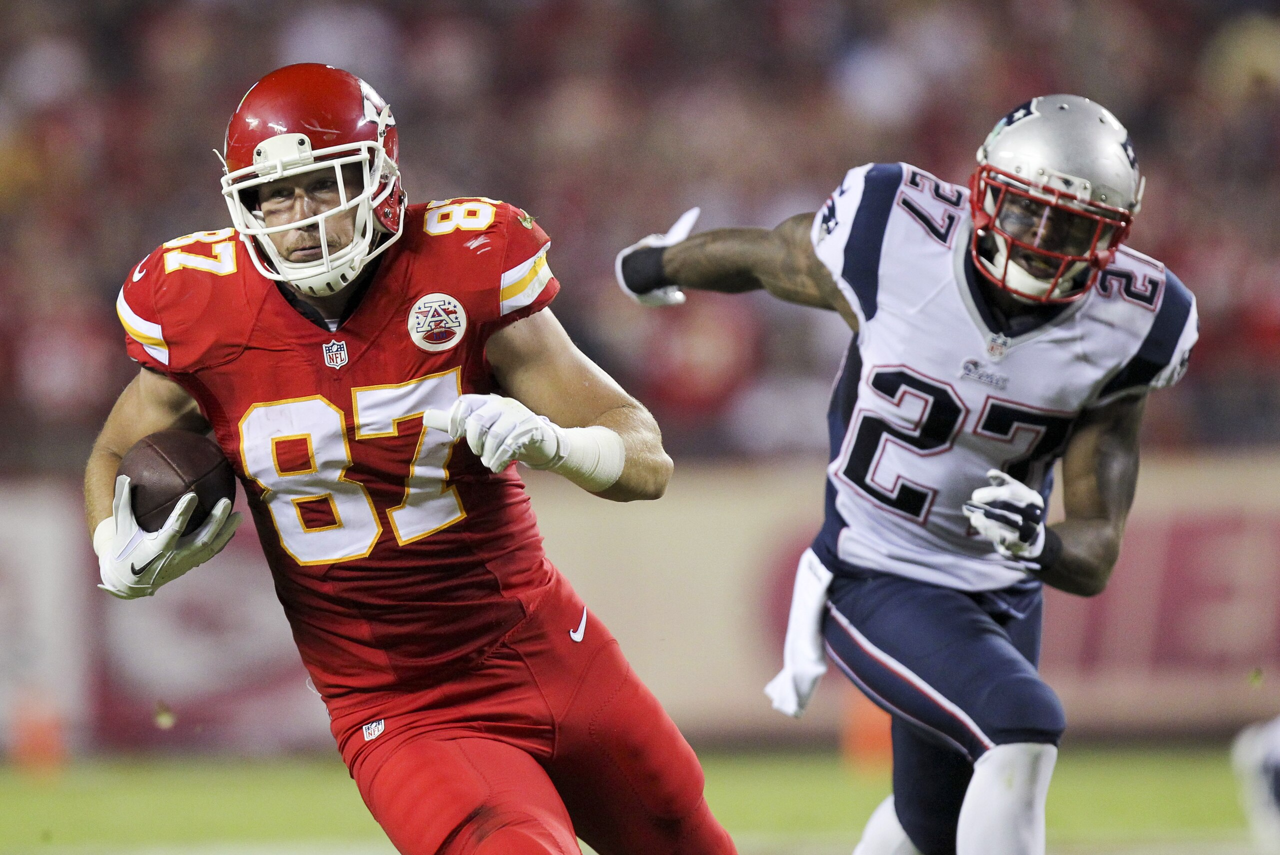 Kansas City Chiefs tight end Travis Kelce, left, runs past New England Patriots strong safety Tavon Wilson after catching a pass for a 33-yard gain during the second quarter of an NFL football game Monday, Sept. 29, 2014, in Kansas City, Mo. (AP Photo/Ed Zurga)