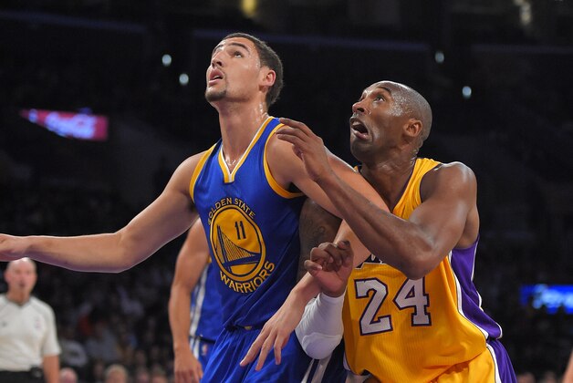Golden State Warriors guard Klay Thompson, left, and Los Angeles Lakers guard Kobe Bryant battle for a rebound during the first half of a preseason basketball game, Thursday, Oct. 9, 2014, in Los Angeles.  (AP Photo/Mark J. Terrill)