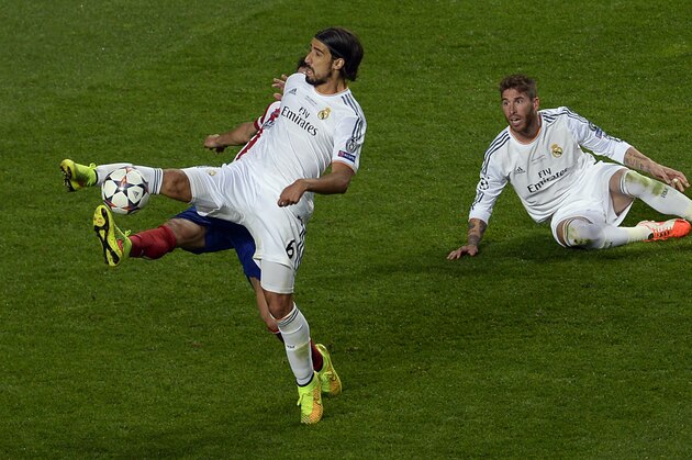Real's Sami Khedira, front, and Atletico's Raul Garcia, hidden,  challenge for the ball during the Champions League final soccer match between Atletico Madrid and Real Madrid in Lisbon, Portugal, Saturday, May 24, 2014. (AP Photo/Paulo Duarte)