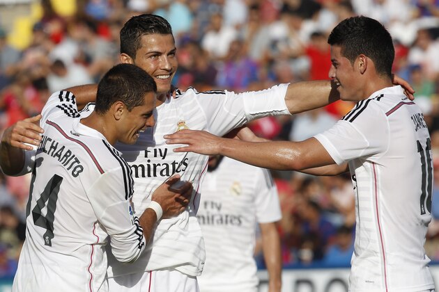 Real Madrid's Cristiano Ronaldo, center, Chicharito, left, and James Rodriguez, right, celebrate after Ronaldo scored against Levante during a Spanish La Liga soccer match at the Ciutat de Valencia stadium in Valencia, Spain, on Saturday, Oct. 18, 2014.(AP Photo/Alberto Saiz)