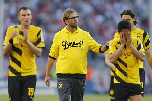 Dortmund's head coach Juergen Klopp, second from left, comforts players after they lost the German first division Bundesliga soccer match between 1.FC Cologne and BvB Borussia Dortmund in Cologne, Germany, Saturday, Oct. 18, 2014. (AP Photo/Frank Augstein)