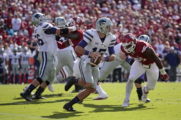 NORMAN, OK - OCTOBER 18: Quarterback Jake Waters #15 of the Kansas State Wildcats scrambles as defensive tackle Quincy Russell #95 of the Oklahoma Sooners pursues October 18, 2014 at Gaylord Family-Oklahoma Memorial Stadium in Norman, Oklahoma.  (Photo by Brett Deering/Getty Images)