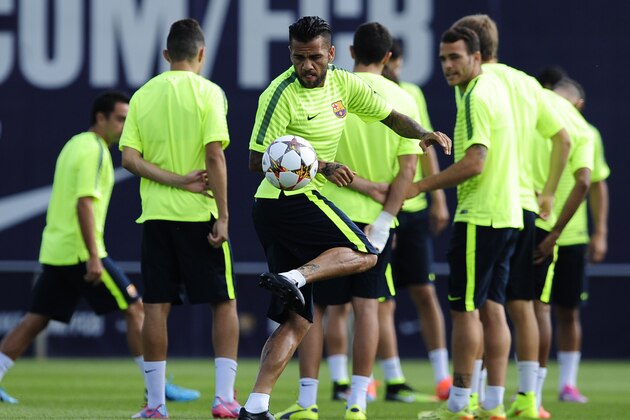 FC Barcelona's Dani Alves, center, controls the ball during a training session at the Sports Center FC Barcelona Joan Gamper in San Joan Despi, Spain, Tuesday, Sept. 16, 2014. FC Barcelona will play against Apoel in a group F Champions League on Wednesday Sept. 17. (AP Photo/Manu Fernandez)