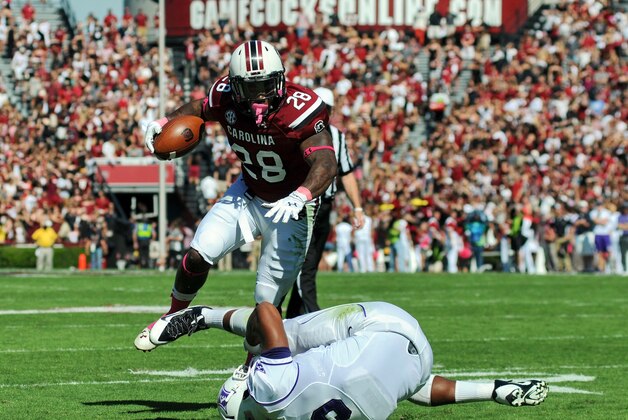 South Carolina running back Mike Davis (28) jumps over Furman's Gary Wilkins on his way to the end zone for a first half touchdown during an NCAA college football game in Columbia, S.C.,  Saturday, Oct. 18, 2014. (AP Photo/ Richard Shiro)