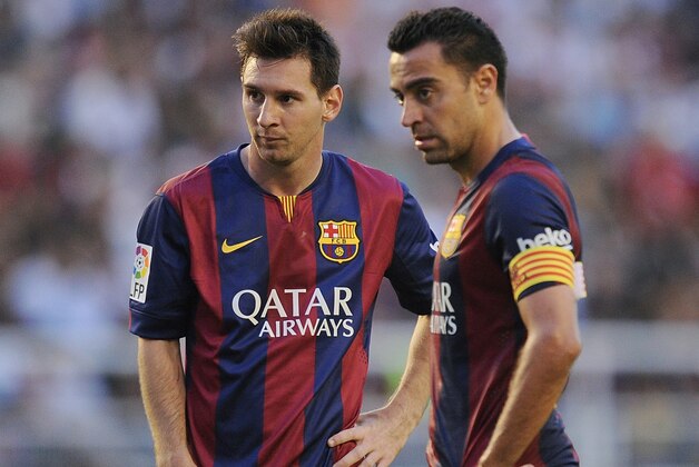 MADRID, SPAIN - OCTOBER 04:  Xavi Hernandez (R) and Lionel Messi line-up a free kick during the La Liga match between Rayo Vallecano de Madrid and FC Barcelona at Estadio Teresa Rivero on October 4, 2014 in Madrid, Spain.  (Photo by Denis Doyle/Getty Images)