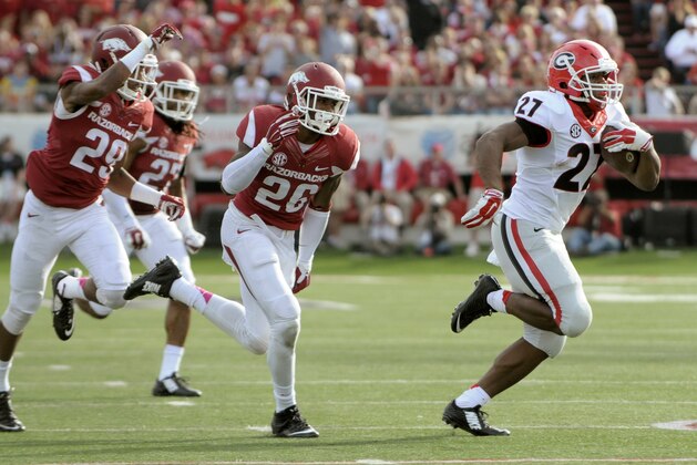 Georgia running back Nick Chubb (27) outruns Arkansas cornerback Jared Collins (29), safety Rohan Gaines (26) and safety Alan Turner (27) for a 43-yard touchdown rush in the second quarter of an NCAA college football game in Little Rock, Ark., Saturday, Oct. 18, 2014. (AP Photo/David Quinn)